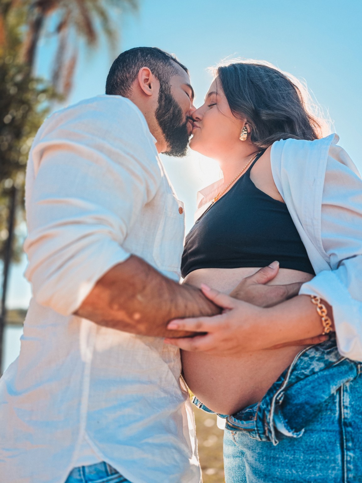 Casal se beijando durante o ensaio de gestante