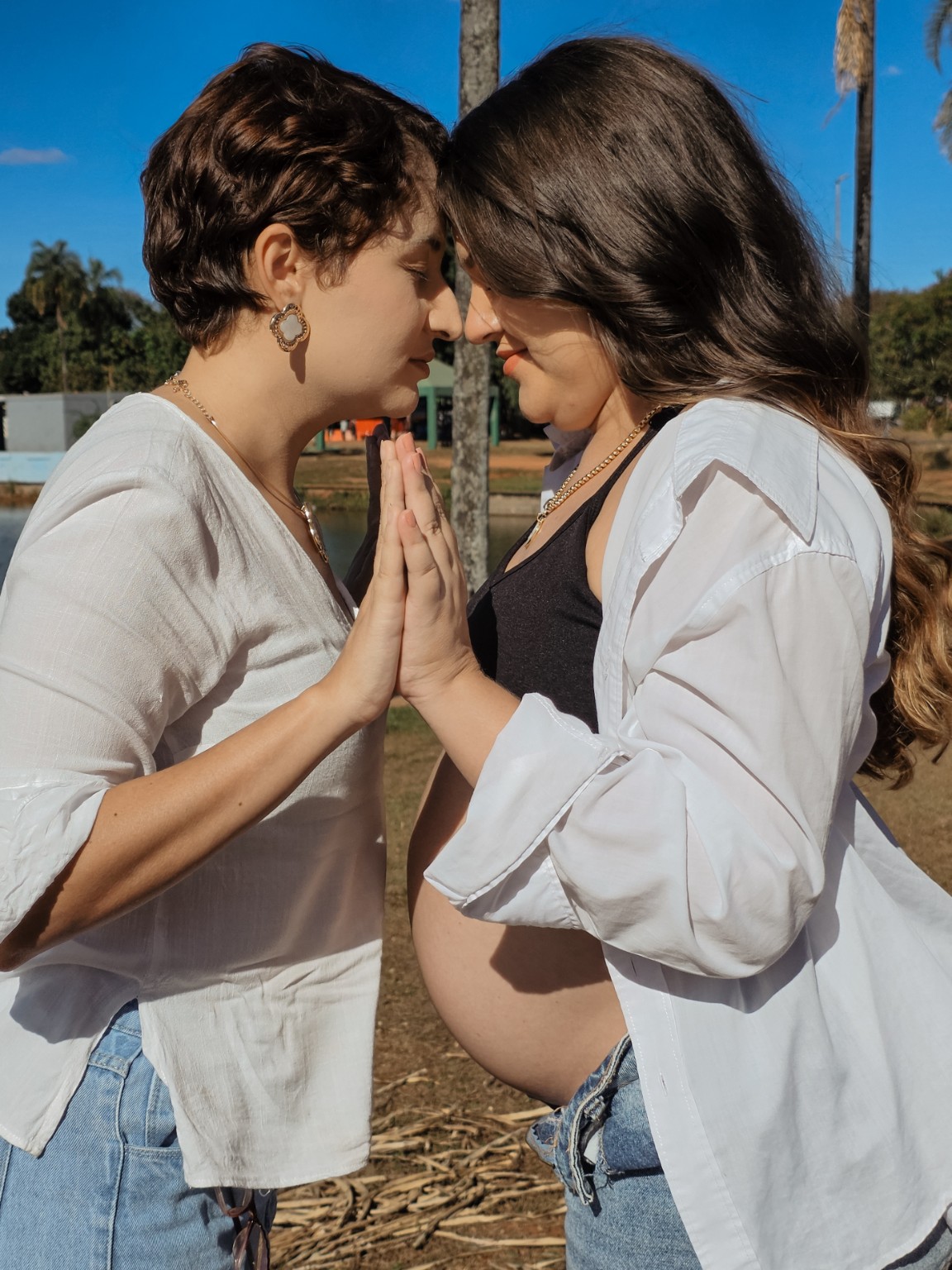 Duas irmãs com as mãos unidas durante o ensaio de gestante